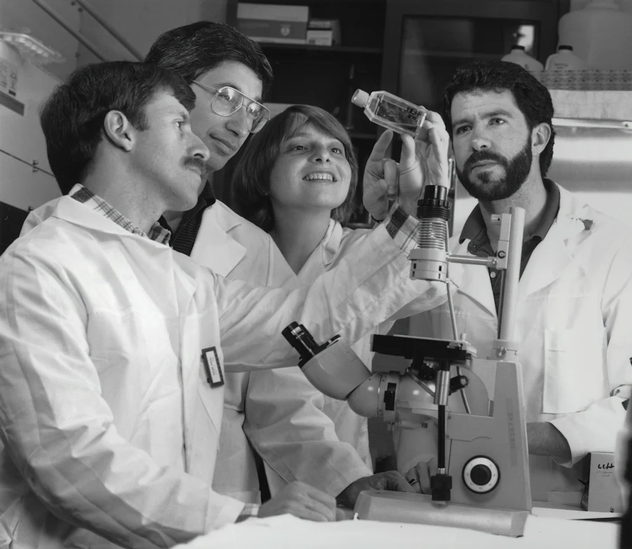 Medical researchers collaborating around a microscope